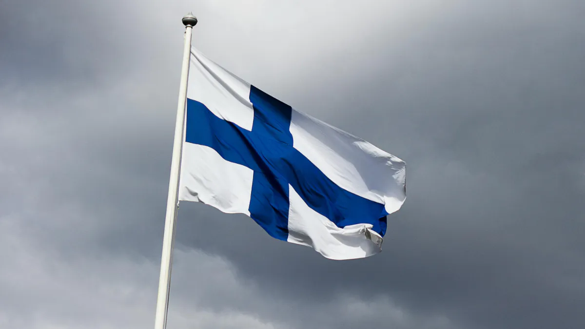 a Finnish flag against a dark grey sky