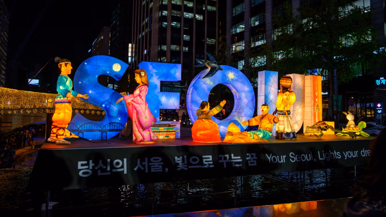 a big light installation of the letters "SEOUL" and a series of characters wearing traditional clothing